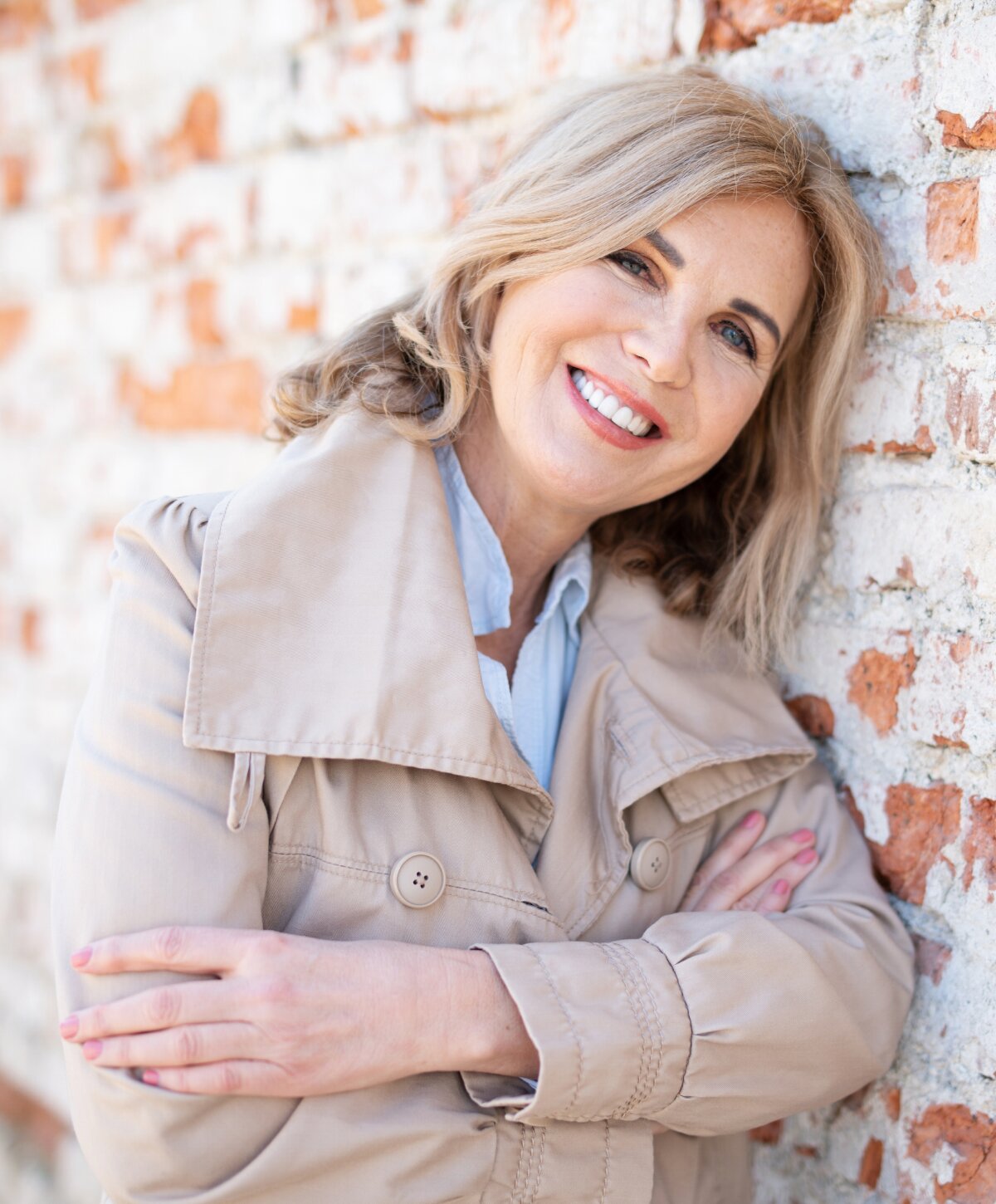 Nashville facial fat grafting model leaning on wall and smiling